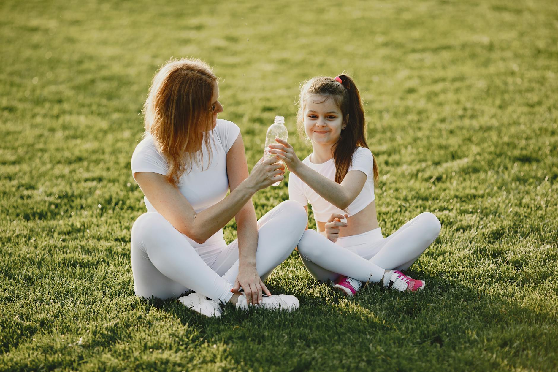 Mama i córka w sportowych strojach odpoczywają razem na świeżym powietrzu