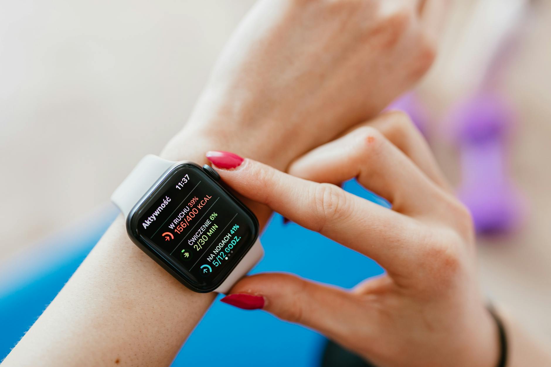 Kobieta na macie do jogi sprawdza puls na smartwatchu