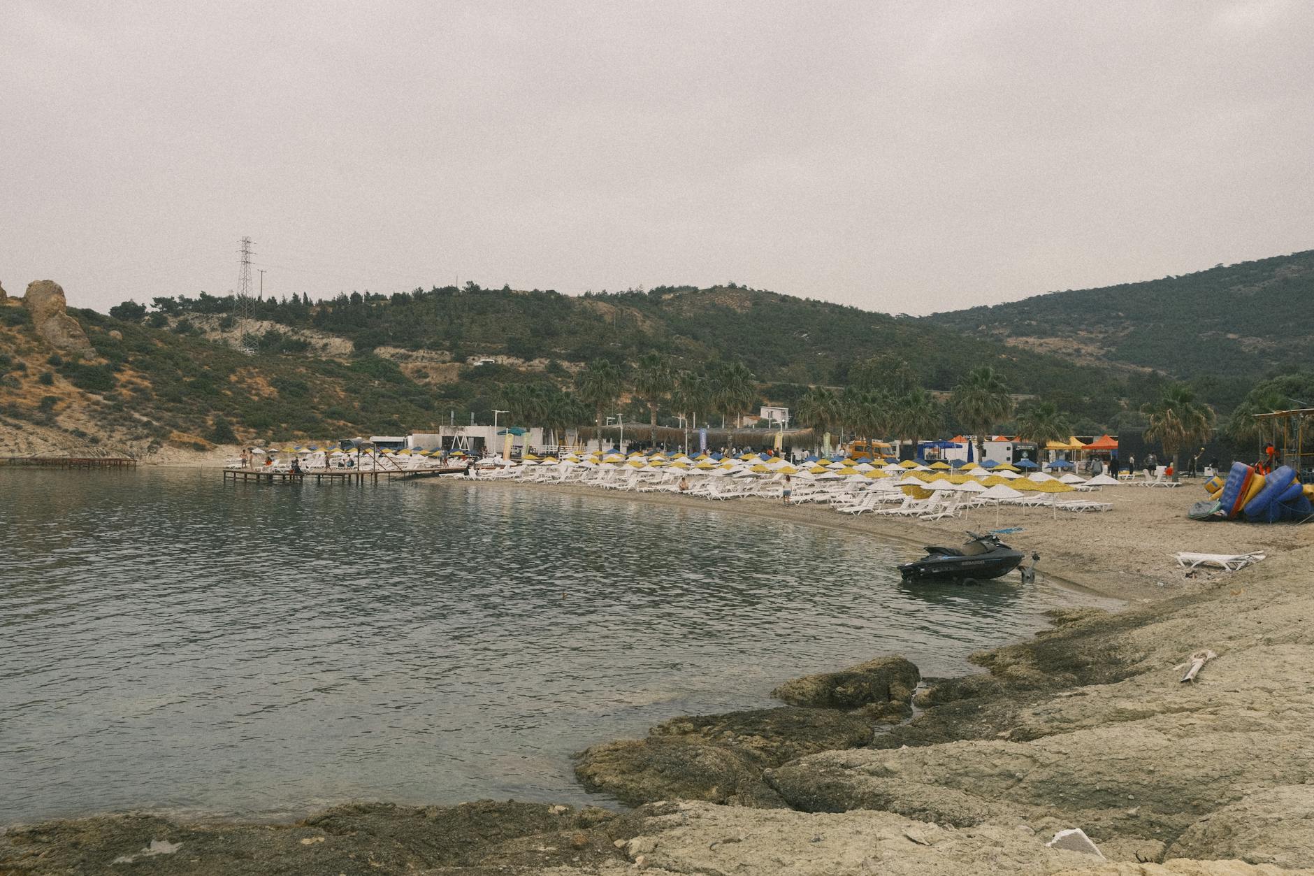 Spokojna plaża z leżakami i skalistym wybrzeżem w Izmirze, Turcja