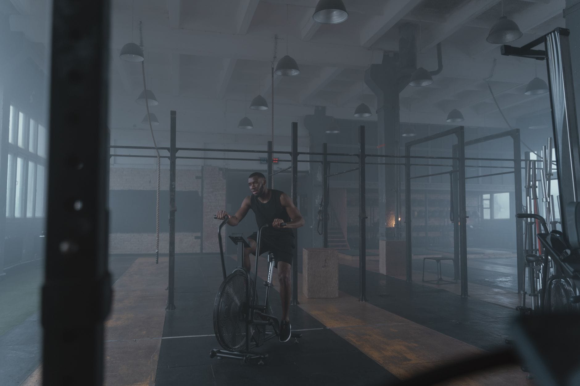 Zawodnik na rowerze stacjonarnym wykonuje trening tlenowy w siłowni